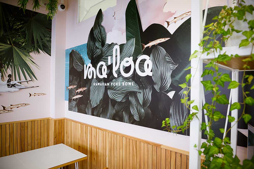 Wandtatoo mit dem Firmennamen Ma'Loa Hawaiian Poké Bowl auf bunt gestalteter Wand